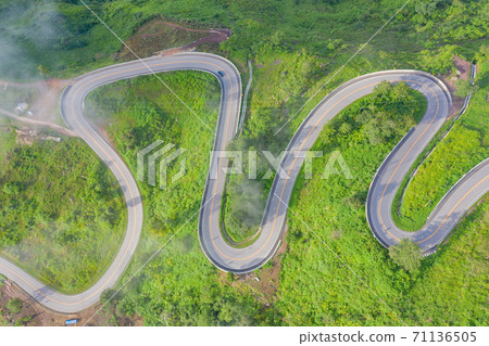 Aerial view of cars driving on curved, zigzag curve road or street on mountain hill with green natural forest trees in rural area of Phu Tub Berk, Phetchabun, Thailand. 71136505
