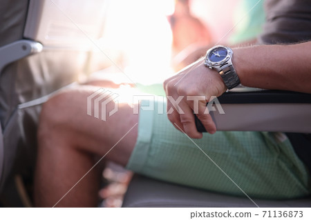 Man is sitting in an airplane seat and holding on to armrest. Man is sitting in an airplane seat and holding on to armrest. 71136873