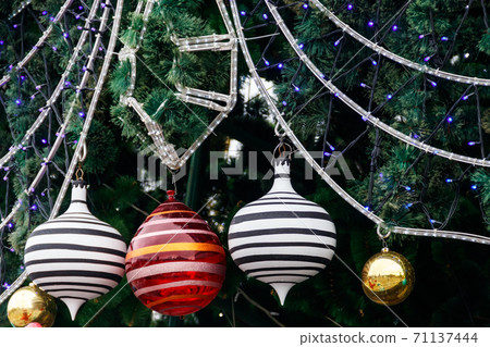Beautiful Christmas decorations hanging on Christmas tree 71137444