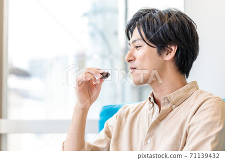 A businessman eating a snack on the sofa A businessman eating a snack on the sofa 71139432