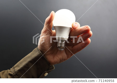 Included led new lamp in human hand on dark background 71140958