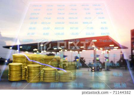 piles of coins and fueling station blur background with chart 71144382