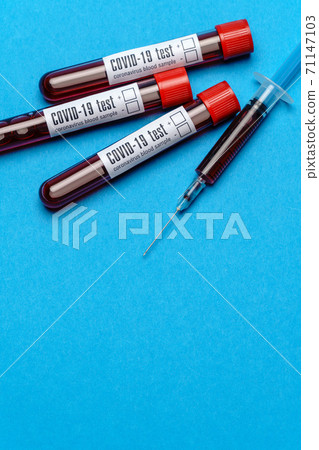 Syringe And Plastic Test Tube With Blood Sample over blue background with copyspace Syringe And Plastic Test Tube With Blood Sample over blue background with copyspace 71147103