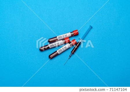 Syringe And Plastic Test Tube With Blood Sample over blue background with copyspace Syringe And Plastic Test Tube With Blood Sample over blue background with copyspace 71147104