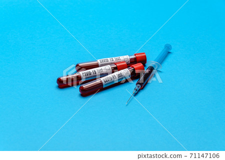 Syringe And Plastic Test Tube With Blood Sample over blue background with copyspace Syringe And Plastic Test Tube With Blood Sample over blue background with copyspace 71147106