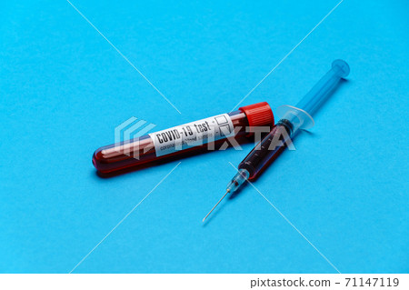 Syringe And Plastic Test Tube With Blood Sample over blue background with copyspace Syringe And Plastic Test Tube With Blood Sample over blue background with copyspace 71147119