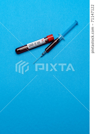 Syringe And Plastic Test Tube With Blood Sample over blue background with copyspace Syringe And Plastic Test Tube With Blood Sample over blue background with copyspace 71147122