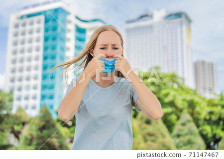 Improper wearing of mask concept. Woman scratching his nose under the mask, touches the mask Improper wearing of mask concept. Woman scratching his nose under the mask, touches the mask 71147467