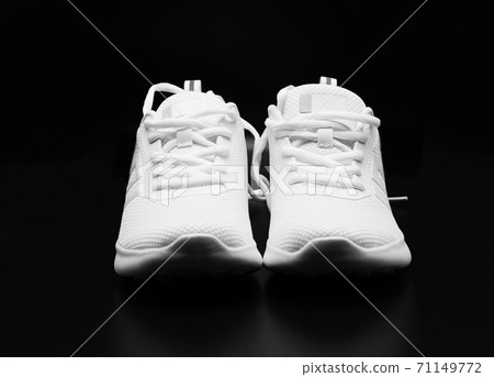 a pair of woman white sneakers on black a pair of woman white sneakers on black 71149772