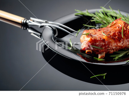 Grilled meat sprinkled with rosemary on a black background. Grilled meat sprinkled with rosemary on a black background. 71150976