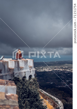 Young woman contemplating the landscape from Palacio da Pena in Sintra, Portugal Young woman contemplating the landscape from Palacio da Pena in Sintra, Portugal 71151754