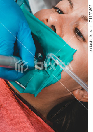 dentist treats the tooth with modern methods, uses a rubber dam, sterile tooth treatment. 71151802