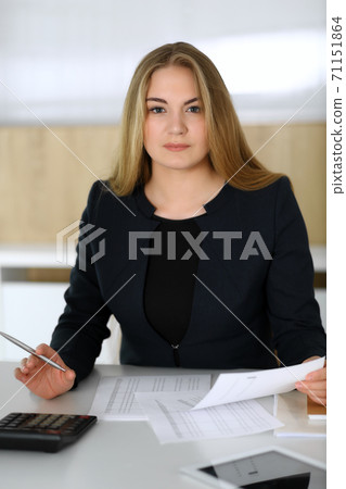 Blonde business woman sitting and working with computer in office. Accountant and secretary making report. Audit, tax service concepts Blonde business woman sitting and working with computer in office. Accountant and secretary making report. Audit, tax service concepts 71151864