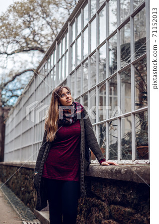 Young woman contemplating an urban greenhouse 71152013