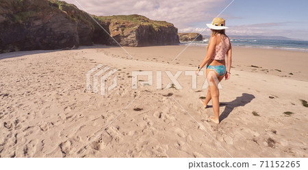 Woman walking by a beach in Galicia, Spain 71152265