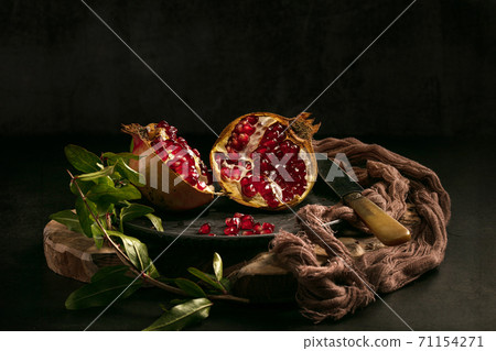 Pomegranate and open pomegranate in a plate Pomegranate and open pomegranate in a plate 71154271