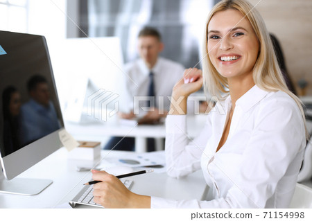 Business woman looks happy and excited at workplace in modern office. Secretary or female lawyer working for pleasure and success 71154998