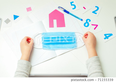 Little girl is holding medical mask. 71155339