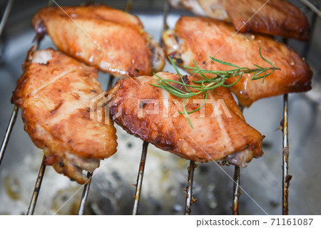 chicken wings grilled on grill with sauce herbs and spices cooking thai asian food rosemary chicken / chicken wings grilled on grill with sauce herbs and spices cooking thai asian food rosemary chicken / 71161087