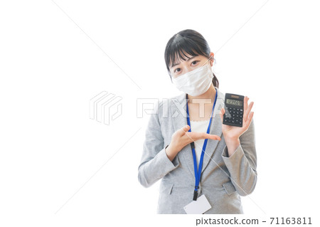 A young business person wearing a mask and holding a calculator A young business person wearing a mask and holding a calculator 71163811