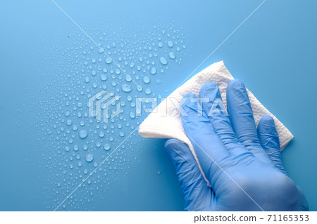 hand in blue rubber gloves cleaning table with cloth hand in blue rubber gloves cleaning table with cloth 71165353
