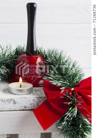 Chritmas red bow, bell and lit candle Chritmas red bow, bell and lit candle 71166736