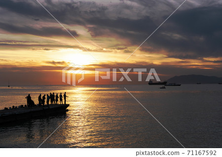 fishermen silouettes on sunset background. fishermen silouettes on sunset background. 71167592