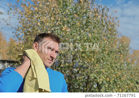 Handsome sportsman wipe sweat from a neck with towel Handsome sportsman wipe sweat from a neck with towel 71167791