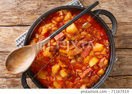 South American Locro stew of pumpkin, beans, corn and meat close-up in a pot. horizontal top view South American Locro stew of pumpkin, beans, corn and meat close-up in a pot. horizontal top view 71167819