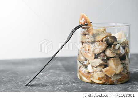 canned forest mushrooms with a fork  71168091