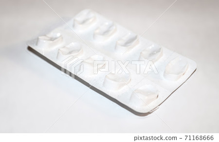Pharmacy drugstore concept. Packs of white pills packed in blisters with copy space isolated on a white background. Focus on foreground, soft bokeh. Pharmacy drugstore concept. Packs of white pills packed in blisters with copy space isolated on a white background. Focus on foreground, soft bokeh. 71168666