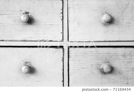 Furniture detail shot of vintage old white wooden chest of drawers background texture 71169434