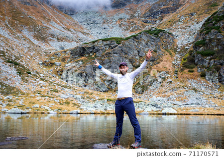 handsome man and his dog trekking in high mountains handsome man and his dog trekking in high mountains 71170571