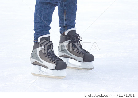 Legs of a man skating on an ice rink. Hobbies and sports. Vacations and winter activities. 71171391
