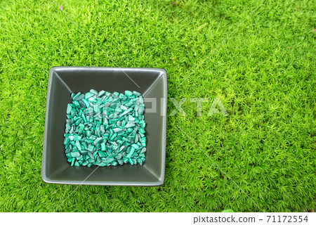 Malachite sazare stone on a plate on moss Malachite sazare stone on a plate on moss 71172554