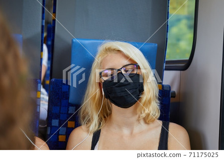 Young woman on a train wearing mask Young woman on a train wearing mask 71175025