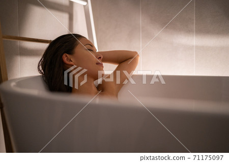 Luxury bath woman relaxing in hotel spa bathtub or home bathroom for total relaxation. Asian lady taking a bath sleeping in warm water, winter wellness Luxury bath woman relaxing in hotel spa bathtub or home bathroom for total relaxation. Asian lady taking a bath sleeping in warm water, winter wellness 71175097