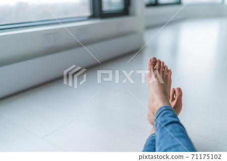 Home relax comfort lifestyle woman barefoot relaxing at warm radiators heat system in apartment or condo living. Cozy winter electric baseboards in house. Closeup of feet Home relax comfort lifestyle woman barefoot relaxing at warm radiators heat system in apartment or condo living. Cozy winter electric baseboards in house. Closeup of feet 71175102