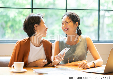 A woman talking to a friend at a cafe 71176341