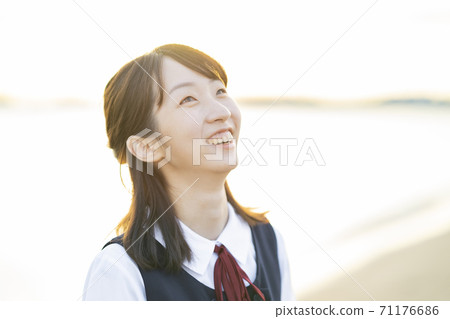 Asian female high school student wrapped in the setting sun Asian female high school student wrapped in the setting sun 71176686