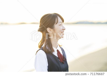 Asian female high school student wrapped in the setting sun 71176687