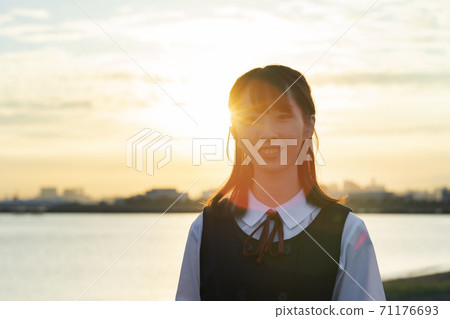 Asian female high school student wrapped in the setting sun Asian female high school student wrapped in the setting sun 71176693