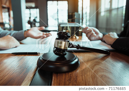 Legal advisor is explaining the offense under the law in the book at office. 71176885