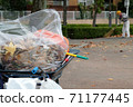 A man cleaning the fallen leaves in the park 71177445