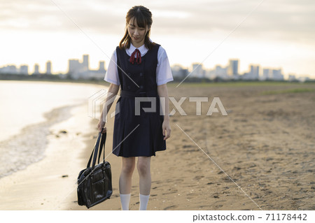 Asian female high school student walking on the beach Asian female high school student walking on the beach 71178442