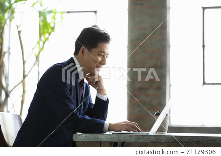 A businessman in his 50s wearing a suit A businessman in his 50s wearing a suit 71179306