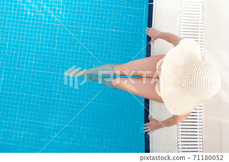 Woman relaxing in swimming pool 71180052