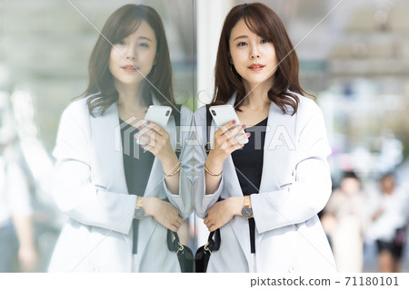 Young woman with a smartphone outdoors Young woman with a smartphone outdoors 71180101