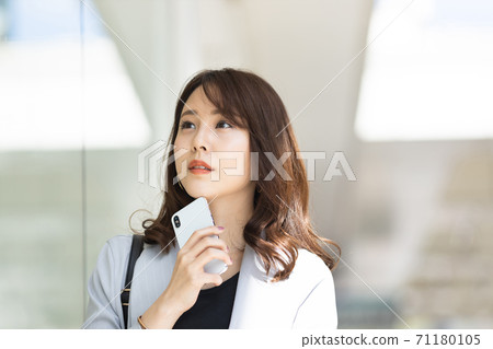 Young woman with a smartphone outdoors Young woman with a smartphone outdoors 71180105