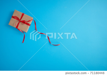 Gift box with a red bow on a blue Gift box with a red bow on a blue 71180448